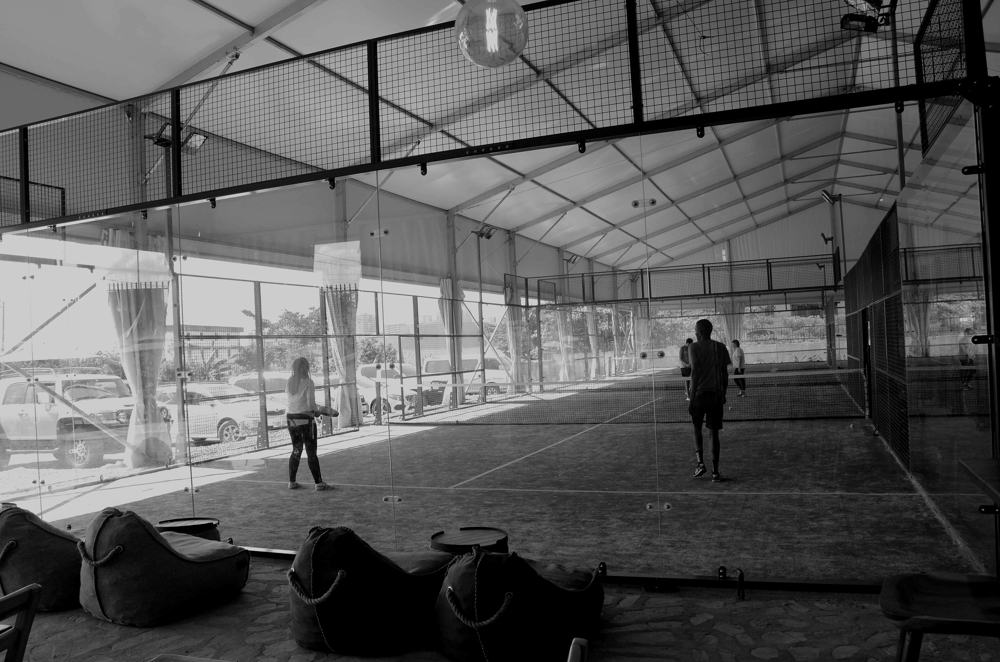 An indoor padel court in the evening, in black and white